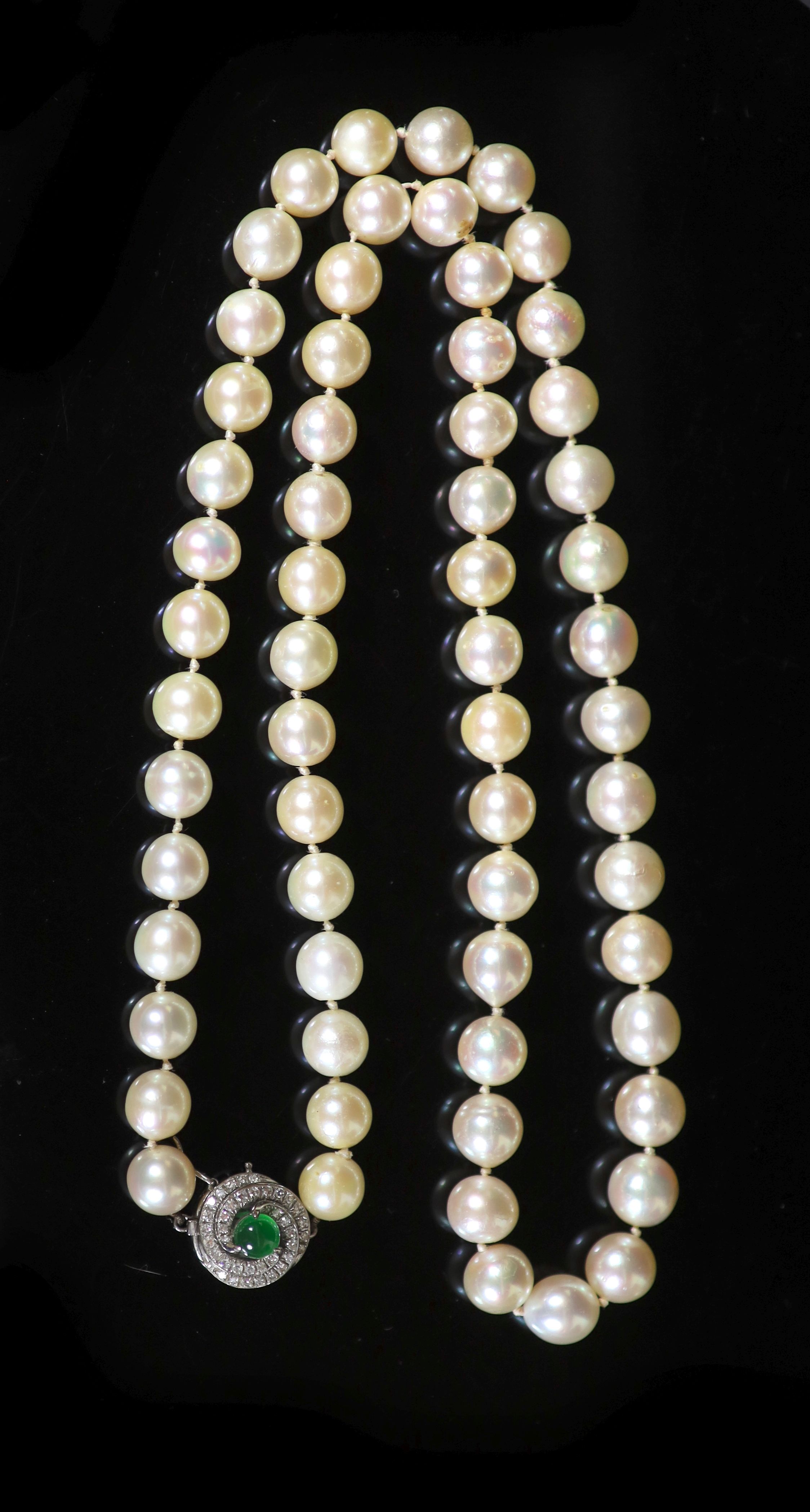 A single strand uniform cultured pearl necklace with diamond and cabochon emerald set clasp,
